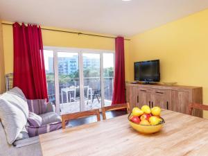 a living room with a table with a bowl of fruit on it at Apartment Santa Cruz by Interhome in Blanes