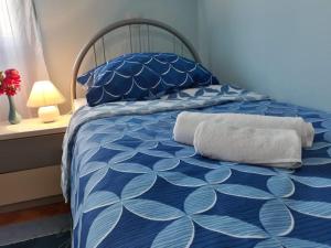 uma cama azul e branca com toalhas em Apartman Slavonija em Osijek