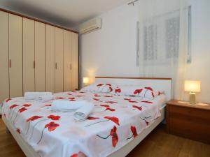 ein Schlafzimmer mit einem Bett mit roten Blumen darauf in der Unterkunft Apartment Nina by Interhome in Mimice