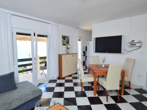 ein Wohnzimmer mit Tisch und Stühlen und einem Fernseher in der Unterkunft Apartment Nina by Interhome in Mimice