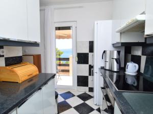 eine Küche mit weißen Schränken und einem schwarz-weiß karierten Boden in der Unterkunft Apartment Nina by Interhome in Mimice + 23 Fotos