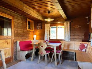 a dining room with a table and chairs in a cabin at Chalet Wassertheureralm by Interhome in Greifenburg