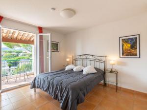 a bedroom with a bed and a large window at Holiday Home Le Mas d'Esquières 7 by Interhome in Les Issambres