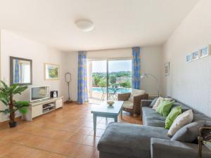 a living room with a couch and a tv at Holiday Home Le Mas d'Esquières 7 by Interhome in Les Issambres