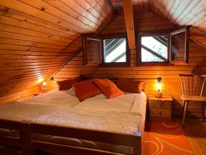 a bed in a wooden cabin with two windows at Chalet Wassertheureralm by Interhome in Greifenburg