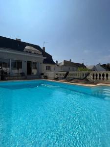 a large blue swimming pool in front of a house at 11 Port Lin in Le Croisic