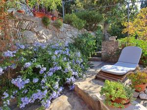 a garden with a chair and purple flowers at Holiday Home Mirna by Interhome in Ložišće