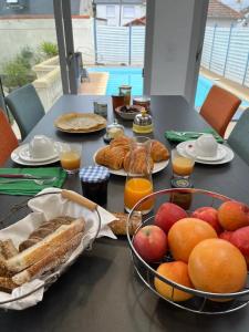 a table with a bowl of fruit and bread and orange juice at 11 Port Lin in Le Croisic