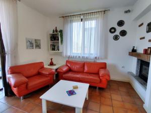 GermignagaにあるApartment Gobetti by Interhomeのリビングルーム(オレンジ色のソファ2台、暖炉付)