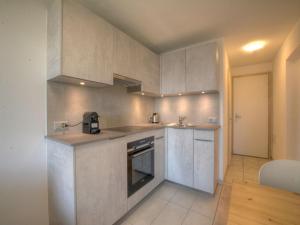 a kitchen with white cabinets and a stove at Apartment Topaze-2 by Interhome in Anzère