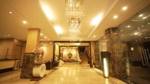 eine große Lobby mit einem Kronleuchter in einem Gebäude in der Unterkunft Hotel Pal Heights in Bhubaneshwar