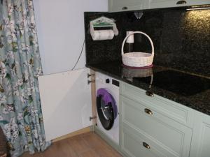 a kitchen with a washing machine in a kitchen at Holiday Home Gwiezdna by Interhome in Walne