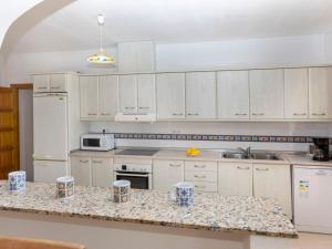 a kitchen with white cabinets and a granite counter top at Villa Aguamarina by Interhome in Miami Platja