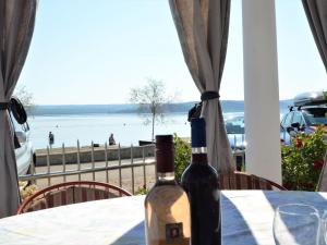 two bottles of wine sitting on a table in front of a beach at Apartment Ivana-5 by Interhome in Raslina