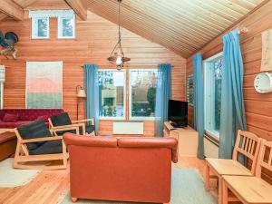 ein Wohnzimmer mit Sofa und Fernseher in der Unterkunft Holiday Home Saapunkijärvi- pitkäperä by Interhome in Saapunki