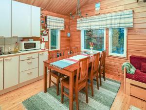 eine Küche mit Tisch und Stühlen in einem Zimmer in der Unterkunft Holiday Home Saapunkijärvi- pitkäperä by Interhome in Saapunki