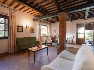 ein Wohnzimmer mit einem Sofa und einem Tisch in der Unterkunft Holiday Home Poggio Campana by Interhome in Montemerano
