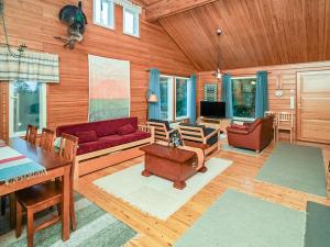 ein Wohnzimmer mit einem roten Sofa und einem Tisch in der Unterkunft Holiday Home Saapunkijärvi- pitkäperä by Interhome in Saapunki