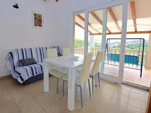a dining room with a table and chairs and a couch at Holiday Home Villa Tonka by Interhome in Sutivan