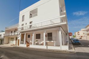 a white building on the corner of a street at Hostal CAN GALLU in Cala Ratjada