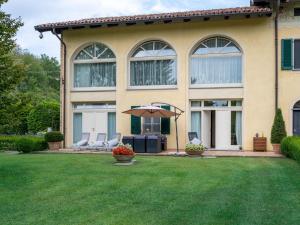 コスティリオーレ・ダスティにあるHoliday Home Villa Carlotta by Interhomeの庭に椅子2脚と傘1脚がある家