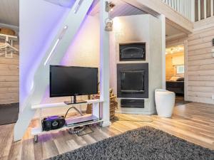 a living room with a tv and a fireplace at Holiday Home Villa helmi by Interhome in Ruka