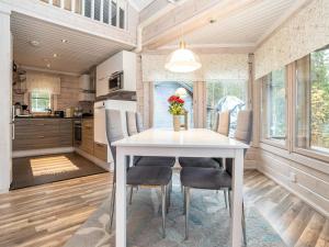 a kitchen and dining room with a white table and chairs at Holiday Home Villa helmi by Interhome in Ruka +19 photos