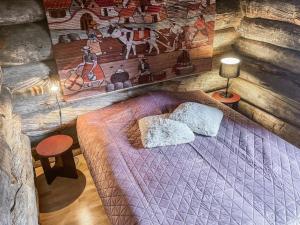 ein Schlafzimmer mit einem Bett in einer Blockhütte in der Unterkunft Holiday Home Tähtiruka 3 by Interhome in Ruka
