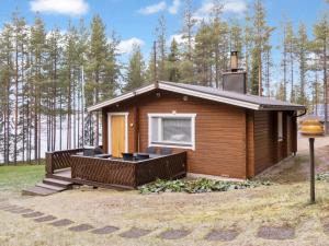 a small cabin with a deck and a window at Holiday Home Järvelä by Interhome in Kemijärvi