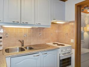 een keuken met witte kasten, een wastafel en een fornuis bij Holiday Home Järvelä by Interhome in Kemijärvi