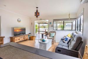 a living room with a couch and a tv at Sunset Haven in Shoalhaven Heads