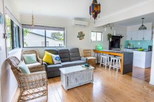 a living room with a couch and a kitchen at Sunset Haven in Shoalhaven Heads