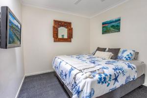 a bedroom with a bed and a mirror at Sunset Haven in Shoalhaven Heads