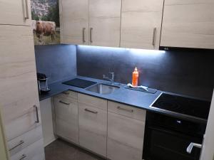 a kitchen with a sink and a stove top oven at Apartment Ringstrasse - Utoring-14 by Interhome in Leukerbad