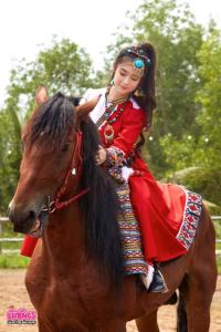 Una mujer con un vestido rojo montando a caballo en Tanyoli Resort en Phan Rang