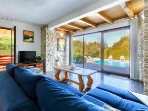 un soggiorno con divano blu e tavolo di Holiday Home Villa Anamaria by Interhome a Plovanija