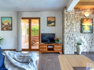 a living room with a television on a wooden cabinet at Holiday Home Villa Anamaria by Interhome in Plovanija