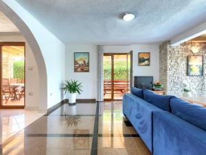 a living room with a blue couch and a tv at Holiday Home Villa Anamaria by Interhome in Plovanija