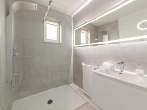 ein weißes Bad mit einem Waschbecken und einer Dusche in der Unterkunft Apartment Wilde Zee by Interhome in Bredene-aan-Zee
