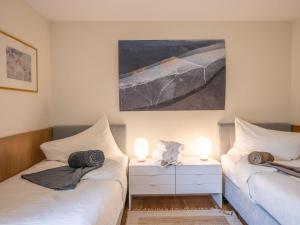 2 Betten in einem Zimmer mit 2 Lampen und einem Gemälde in der Unterkunft Apartment Chesa Daniela B - Anita by Interhome in St. Moritz