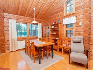 a dining room with a table and chairs in a log cabin at Holiday Home Siula by Interhome in Nissi