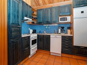 eine Küche mit blauen Schränken und weißen Geräten in der Unterkunft Holiday Home Siula by Interhome in Nissi + 23 Fotos