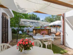 un patio con tavoli bianchi, sedie bianche e ombrelloni di Holiday Home Le Querce - PIT550 by Interhome ad Atri