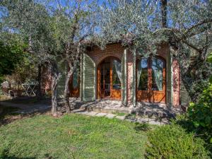 una casa de ladrillo con una puerta arqueada y árboles en Holiday Home Borgo della Limonaia-3 by Interhome, en Pieve a Nievole