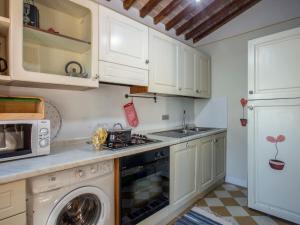 cocina con armarios blancos, lavadora y secadora en Holiday Home Iacopo by Interhome en Pieve a Nievole