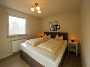 a bedroom with a large bed with two candles on it at Apartment Müritz Ferienpark Röbel-6 by Interhome in Röbel