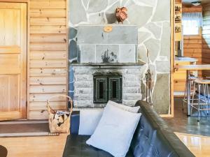 a living room with a stone fireplace and a couch at Holiday Home Sakumaja by Interhome in Levi