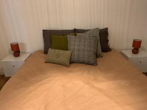 Una cama con tres almohadas encima. en Appartement refait à neuf avec vue sur la ville en Poitiers