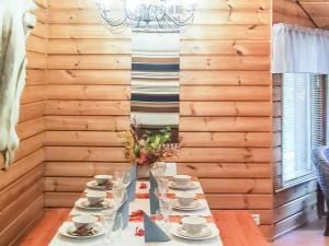 un tavolo con tazze e piattini in una stanza con pareti in legno di Holiday Home Sakumaja by Interhome a Levi