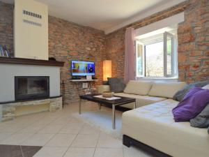 ein Wohnzimmer mit einem Sofa und einem Kamin in der Unterkunft Holiday Home Marija by Interhome in Bogatić